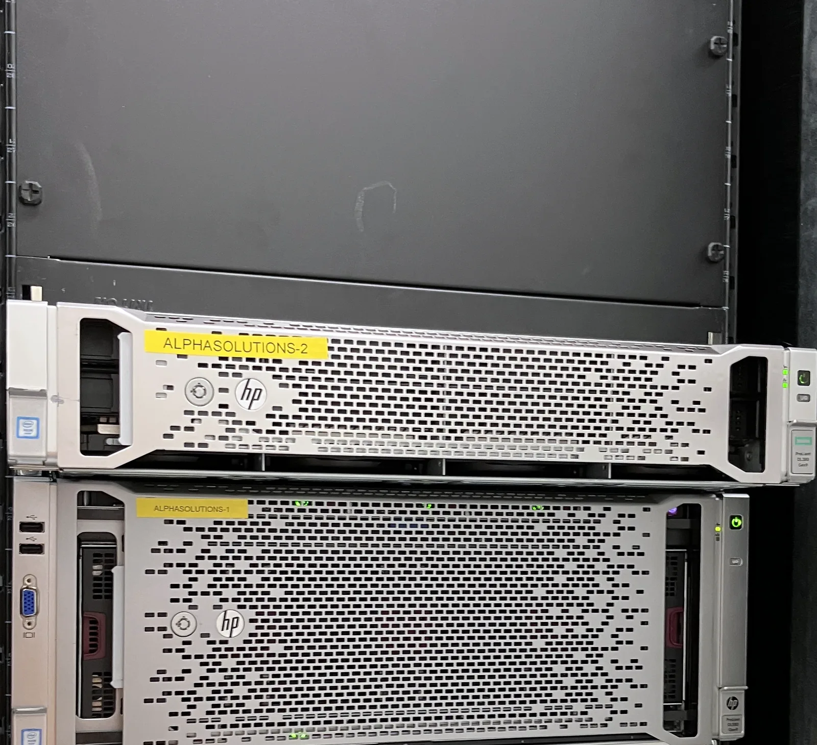 Pohled na rack se dvěma zapnutými servery pro AI Agent harness - servery 2U a 4U - oba se žlutou nálepkou AlphaSolutions.